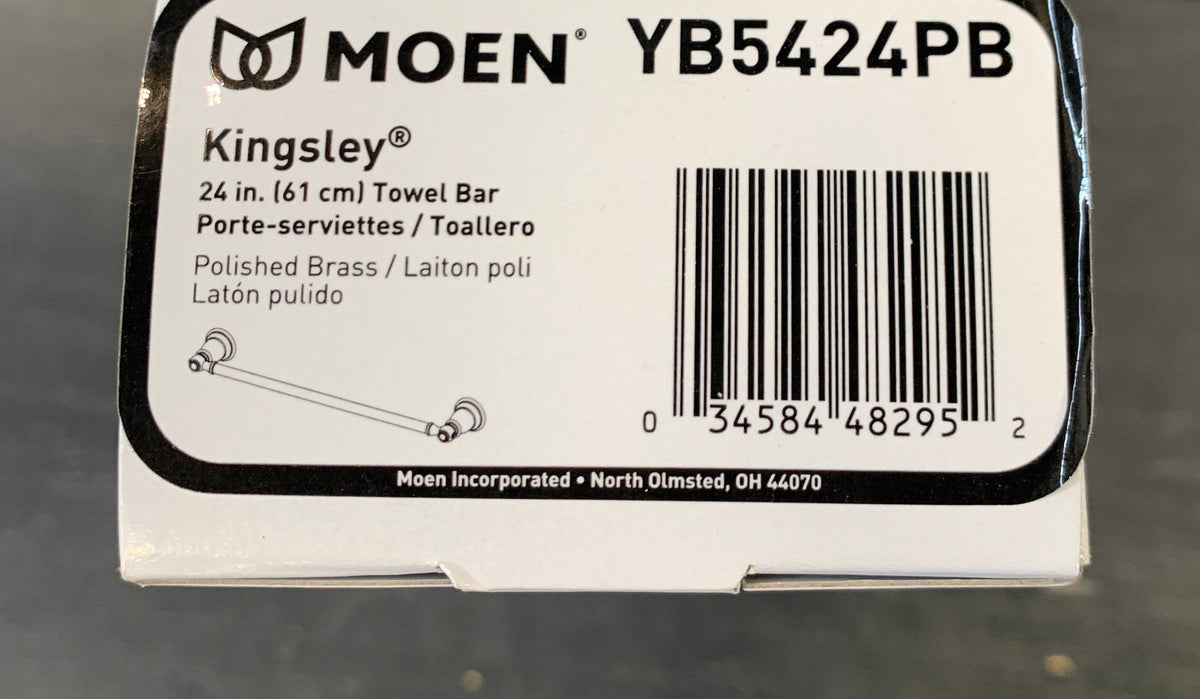 A white Moen YB5424PB product box for Kingsley Bells polished brass ladders, photographed on a gray floor.
