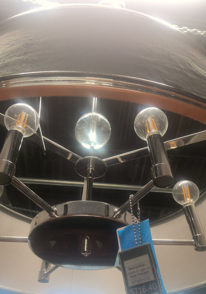A modern multi-light chandelier with a polished chrome finish and clear glass globe bulbs, shown hanging from a ceiling in a store. A blue retail price tag is attached to the fixture.